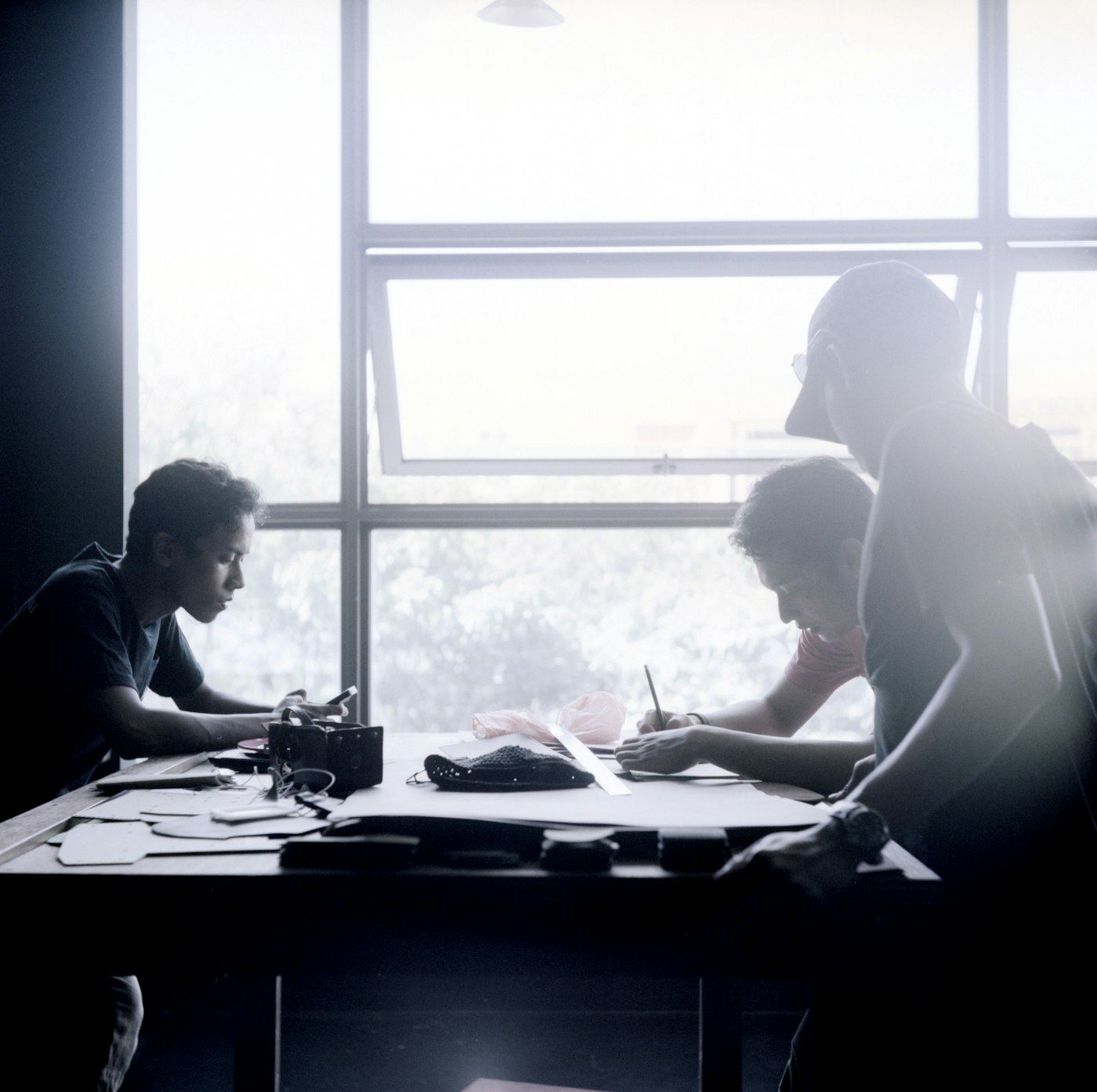 Team silhouetted against a bright office window